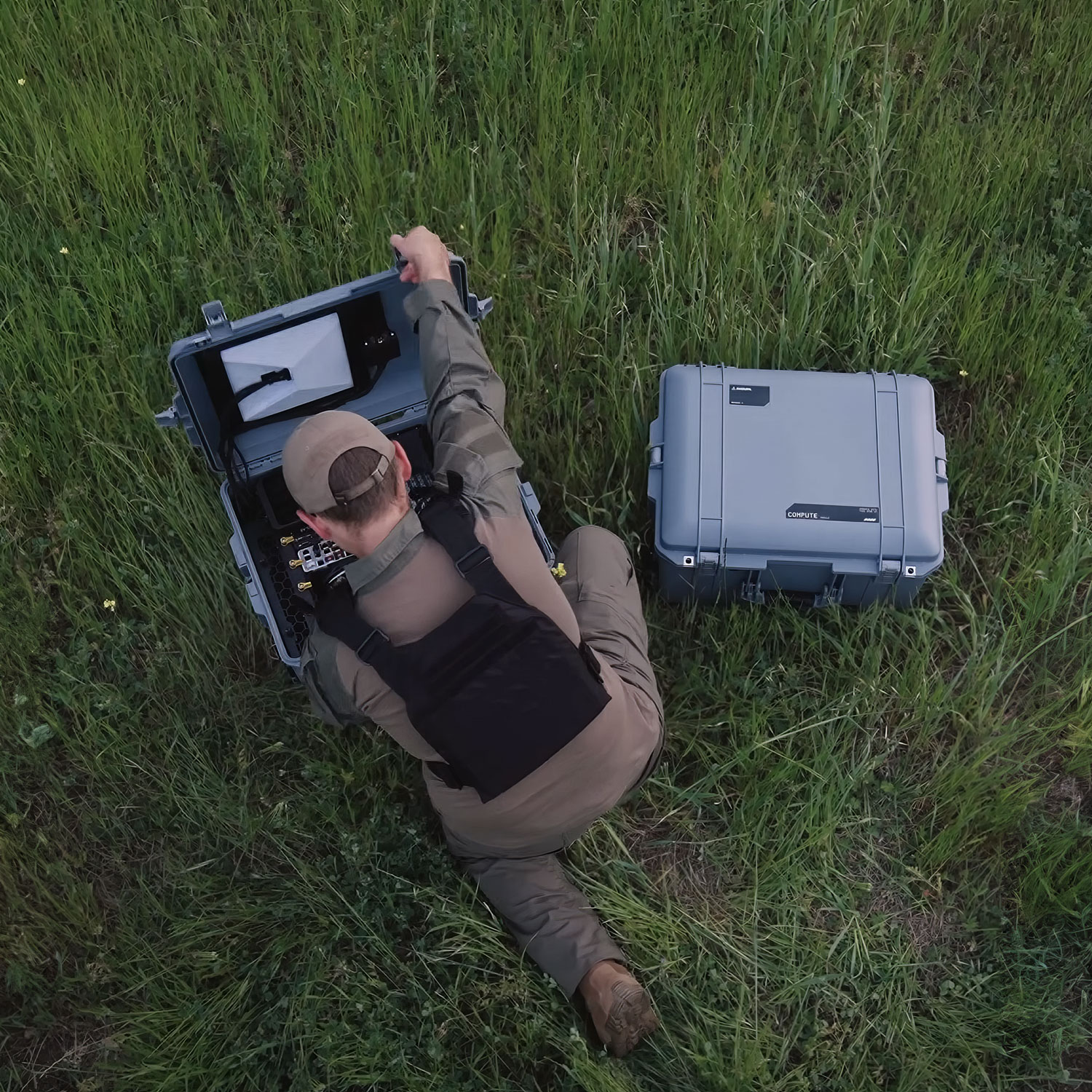 Operator deploying a field compute kit in tall grass